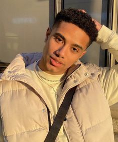 a young man is holding his hair in front of him and posing for the camera