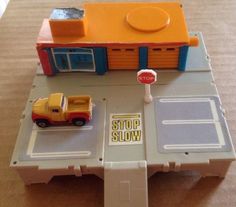 a toy truck is parked in front of a stop and slow sign on a table