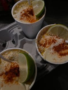 three cups filled with ice cream and topped with limes, cinnamon sprinkled on top