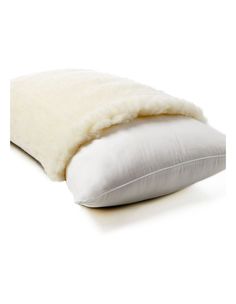 a white pillow with a fur lined cover on it's side and the bottom half rolled up