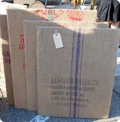 three cardboard boxes sitting on the ground with some tags attached to them and people walking by