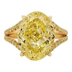 From SCARSELLI, a simply important ring featuring a 6.00 carats Fancy Intense Yellow Oval cut diamond (GIA VS2 Clarity Certificate 5202490787) surrounded by 0.48 carats of Fancy Intense Yellow Round brilliant diamonds in a coordinating handmade mounting of 18k yellow gold. This ring may be sized or re-designed with Scarselli to suit the client's specifications. Should a client wish to customize settings to personalize the look, such as changing side stones or bands, we are happy to accommodate s Luxury Oval Yellow Sapphire Diamond Ring, Exquisite Yellow Oval Rings, Luxury Vintage Yellow Rings, Luxury Yellow Sapphire Gemstone Ring, Luxury Yellow Sapphire Ring, Fine Jewelry, Yellow Diamond Ring, Canary Diamond, Flower Diamond Ring, Marquise Shape Diamond