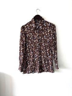 It's a Vintage 90s brown floral cute romantic shirt, blouse. Butterfly collar. Long sleeves. Button up closure. Lightweight. 150gr. Brand: MORGAN. Size: L - M. Material: Polyester. Great vintage condition. Model's height: 5'8 / 178 cm / Size S. MEASUREMENTS: Shoulders: 16 inch / 42 cm. Sleeve:  23 inch / 60 cm. Bust doubled: 42 inch / 106 cm. Length: 30 inch / 77 cm. Worldwide shipping. Shipping takes to: USA 7-14 days.  EU 4-7 days. Others countries 7-14 days. Brown Floral Print Long Sleeve Blouse, Spring Collared Brown Blouse, Brown Long Sleeve Floral Print Tops, Brown Floral Print Long Sleeve Tops, Brown Collared Spring Blouse, Collared Brown Blouse For Spring, Brown Collared Blouse For Spring, Fall Floral Print Patterned Shirt, Brown Buttoned Shirt For Spring