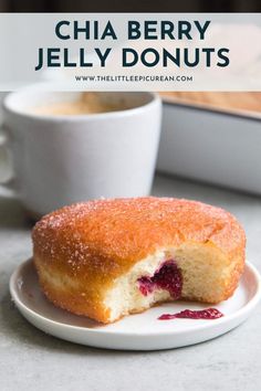 a close up of a doughnut on a plate with a cup of coffee in the background