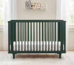 a baby crib in a room with white walls and curtains on the windowsill