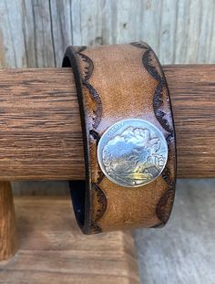 This is a medium brown tooled and antiques leather wrist cuff with a screwback Nickel Indian head Concho..this cuff measures 8 3/4 inches in length and1 inch width...from snap to snap this cuff measures 7 3/4 inches and that means this bracelet will fit a wrist 7 1/4  inches and less... Brown Concho Bracelets As Gift, Brown Western Style Leather Bracelet Gift, Leather Concho Cuff Bracelet, Adjustable Brown Classic Cuff Bracelet, Adjustable Classic Brown Cuff Bracelet, Western Style Brown Cuff Bracelet As Gift, Handmade Western Brown Bracelets, Handmade Western Style Brown Bracelet, Handmade Western Brown Bracelet