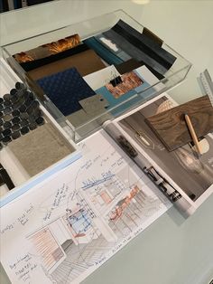 a glass table topped with lots of architectural drawings