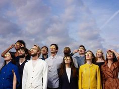 a group of people standing next to each other with their eyes covered by sun glasses