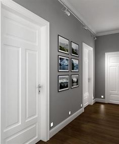 an empty room with white doors and pictures on the wall