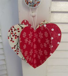 two red hearts hanging from the side of a white door with snowflakes on them