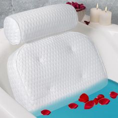 two white towels sitting on top of a bath tub filled with water and roses next to candles