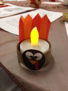 a lit candle with an angry bird on it sitting on a table next to other items