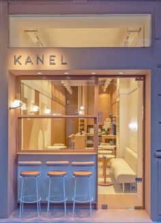 the interior of a store with stools in front of it and lights hanging from the ceiling