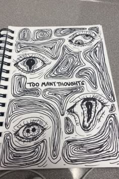 a spiral notebook with the words too many thought on it and an image of two eyes