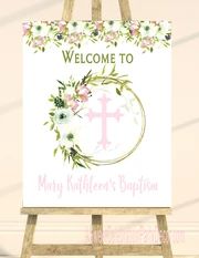 a welcome sign with flowers and a cross on it