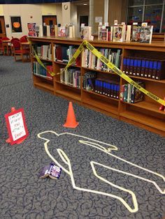 an area with caution tape, bookshelves and orange cones in the middle of it