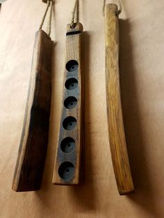 three pieces of wood hanging from ropes on a table