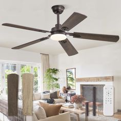 a living room with a ceiling fan and couches