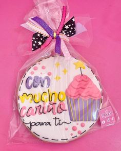 a decorated cookie wrapped in plastic on top of a pink surface with the words con mucho carne para ti