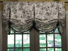 an open window with curtains hanging from it's sides