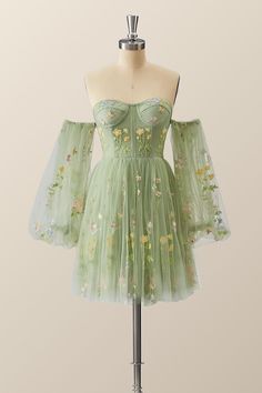 Make a statement in this vibrant, verdant dress! A tulle A-line with floral embroidery, corset bodice, and lacing up the back - it's all topped off with puff-sleeved perfection just above the knee! Hoco Dresses Green Flowy, Green Floral Dress Short, Homecoming Dresses Cottagecore, Fairy Core Dress Short, Homecoming Dresses Enchanted Forest, Homecoming Dress Inspiration, Forest Green Short Dress, Enchanted Forest Dress Short, Enchanted Forest Dress Homecoming