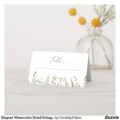 a table name card with flowers in a vase