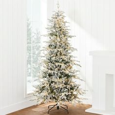 a white christmas tree in a room with wood flooring and wall paint color scheme