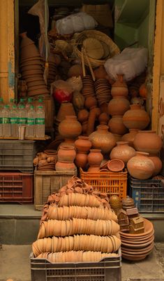 there are many clay pots and bowls on display