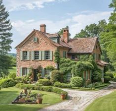 a large brick house surrounded by lush green trees