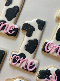 decorated cookies are arranged in the shape of one and two with pink icing on them