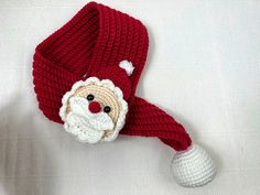 a knitted santa claus hat with a white ball hanging from it's side