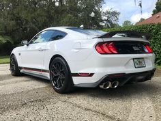 the rear end of a white mustang car