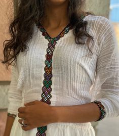 a woman wearing a white dress and a colorful tie