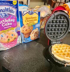 some waffles and other items on a table with eggs, milk, and cake mix