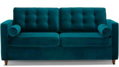 a blue velvet couch with wooden legs and arm rests on an isolated white background,