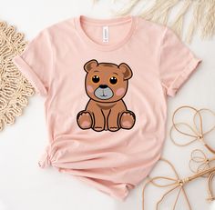 "Teddy Bear T-shirt, Bear Birthday Party   Shirt, Cute Teddy Bear Gift, Self Love Shirts, Love Yourself  Gift, Bear T-shirt, Women's Shirts, Teddy Bear, Teddy Bear, Women's Shirt, Gift For Him, Shirt Embroidery, Embroidered Shirt, Shirt, Women Tee, T-shirt, Premium Tee, Shirt Gift, Gift For Dad, Soft T-shirt This updated unisex essential fits like a well-loved favorite. Super soft cotton and excellent quality print makes one to fall in love with it over and over again. ------------- Fabrication ------------- 100% Combed ring spun cotton Made by specially treating the cotton fibers before spinning them into yarn. The result is stronger and smoother fabric. ------------- Unisex T-shirt Size Chart ------------- XS - - 27\" Length and 18\" Width S - 28\" Length and 19\" Width M - 29\" Length a Cute Short Sleeve T-shirt With Bear Print, Short Sleeve Cartoon Print Top As Gift, Cartoon Print Short Sleeve Top For Gift, Short Sleeve Tops With Cartoon Print For Gift, Cute Bear Print Crew Neck T-shirt, Family Matching Funny Print T-shirt As Gift, Cute Cartoon Print T-shirt For Gift, Cute Cartoon Print T-shirt As Gift, Pink Graphic Tee Shirt For Gift