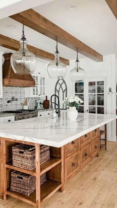 a large kitchen island with lots of drawers and lights hanging from it's ceiling