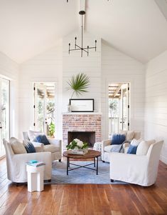 a living room filled with furniture and a fire place in the middle of a room