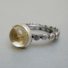 "Citrine rustic silver ring, the gemstone is 0,39\" round cabochon. The design echoes the tablet pattern that decorates the edge of the shank from my Octopus wedding rings. In this ring, I have inserted a beautiful round citrine cabochon into the motif. The ring can also be worn by combining it with the Octopus bands. Weight 0,21 oz Size 8, internal shank diameter 0,670\" Simple jewel, but made original by the craftsmanship, which adds value and characteristics to each of my pieces. Thanks for v Octopus Wedding, Yellow Gemstone Ring, The Octopus, Teardrop Ring, Yellow Gemstones, Handmade Jewel, Stackable Ring