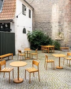 tables and chairs are arranged in an outdoor courtyard area with cobblestone flooring