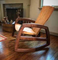 a wooden chair sitting on top of a hard wood floor next to a fire place