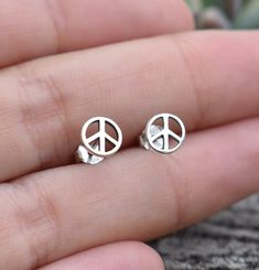 Peace Sign Earrings details:-.925 Solid Sterling Silver.-Matching Sterling butterfly backs.-Measures 6mm round.-Comfortable and lightweight Connect with us on Instagram @a_wild_violet for sales and giveaways!**All items are in stock and ship within 2-5 business days from received payment (excluding Saturday/Sunday) from the US. If you are within the US please expect 3-7 business days for shipping transit and delivery. International orders please expect a minimum of 2 weeks for delivery and upwar Hypoallergenic Adjustable Round Earrings, Adjustable Hypoallergenic Round Earrings, Symbolic Round Earrings For Pierced Ears, Symbolic Round Earrings, Adjustable Round Plug Earrings For Gift, Minimalist Round Plug Earrings As Gift, Sterling Silver Hypoallergenic Round Earrings, Silver Round Plug Earrings For Gift, Symbolic Nickel-free Round Earrings