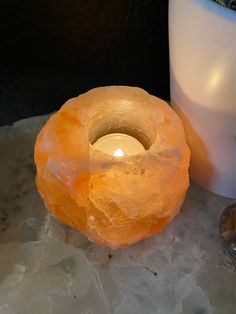 a candle that is sitting next to some rocks