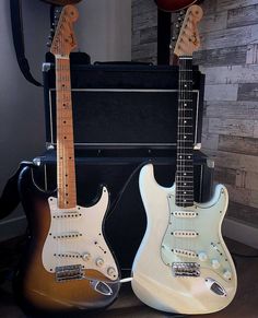 two guitars are sitting next to each other