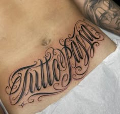 a man's stomach with the word tattoo written in cursive writing on it