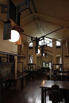 the inside of a restaurant with tables, chairs and an open fire place in it