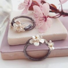 A pretty handmade flower ring based on the Japanese Cherry Blossom in silver and gold. Inspired by Japanese culture and the beautiful cherry blossom, this ring has been hand crafted from sterling silver which has been oxidised to represent the black branches. Cherry blossom has long been symbolic of celebrations and the cycle of life, making this a perfect treat for yourself or a special gift for loved ones. Set with silver blossom with solid gold centres this is a special ring to treasure. Matc Chinese Cherry Blossom, Cherry Blossom Ring, Nature Wedding Ring, Rustic Wedding Rings, Leaf Engagement Ring, Rustic Rings, Floral Engagement Ring, Dried Rose Petals, Cherry Blossom Flowers