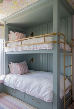 a bunk bed with pink and white pillows