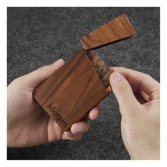 a person holding a wooden business card holder in their hand, with the name madera on it