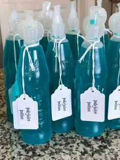 four blue bottles with tags on them sitting on a counter